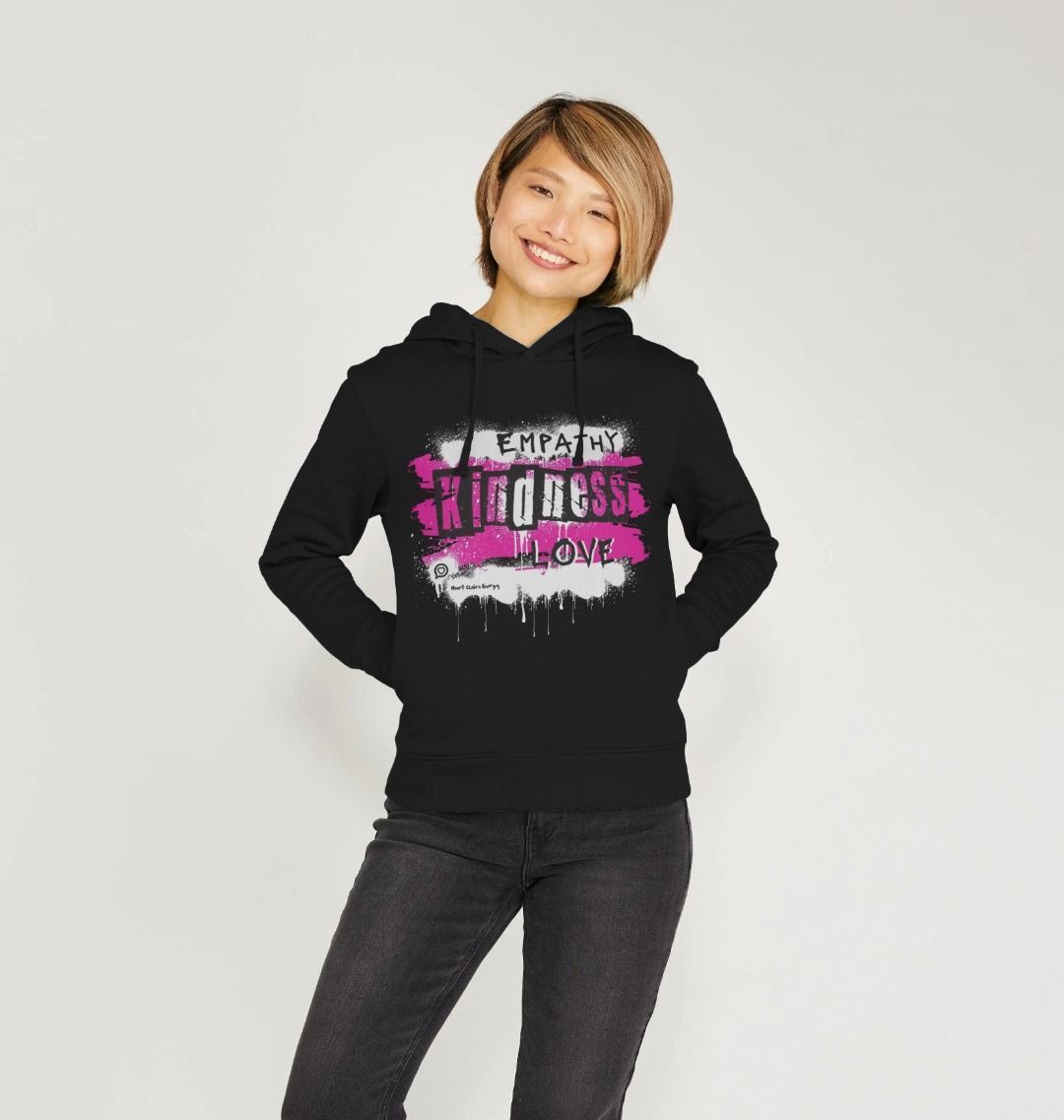 female model wears black hooded sweatshirt with the heart chakra energy design in bright pink 