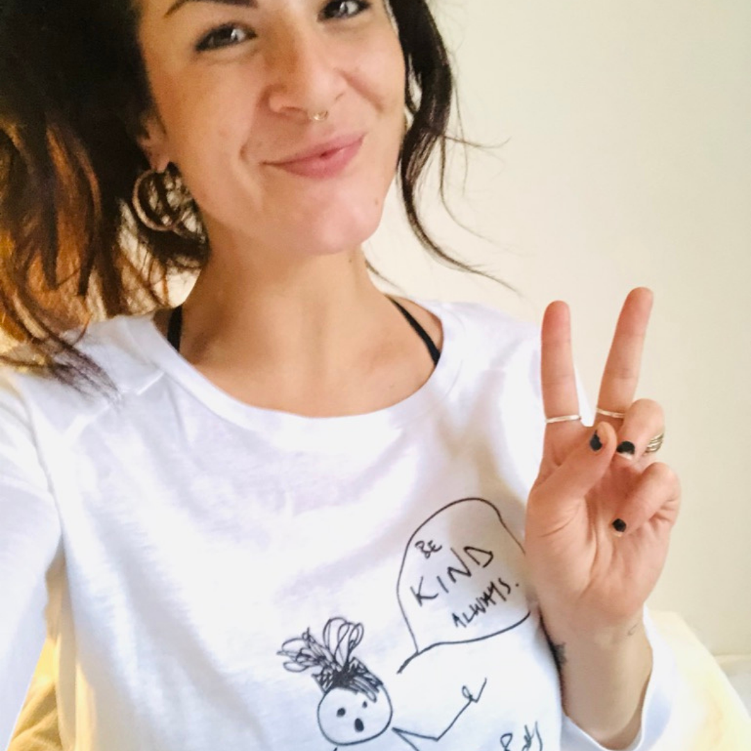 model wearing  wearing white 3/4 sleeve t-shirt with Roo Betty cartoon girl and speech bubble that says Be Kind Always 