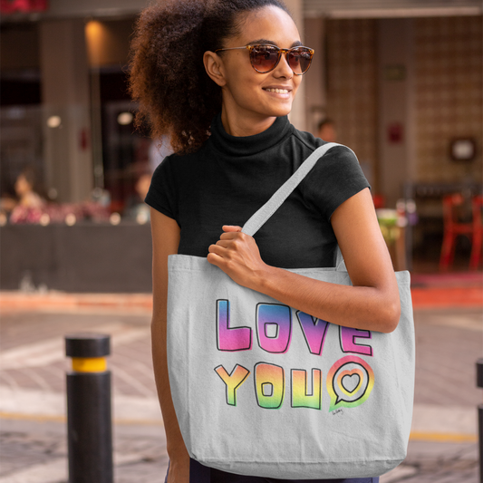 Female model wears black high neck t-shirt carrying a large grey tote bag with the words LOVE YOU in bright rainbow design 