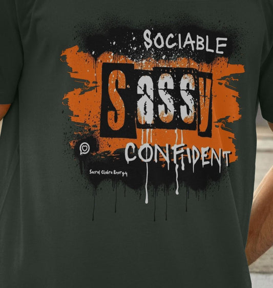 close up photo of the grey unisex t-shirt from the Roo Betty words to empower range , Orange paint splashed design with the words sociable sassy confident to the front in a bold font 